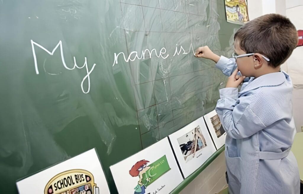 Niño escribe inglés en la pizarra del colegio